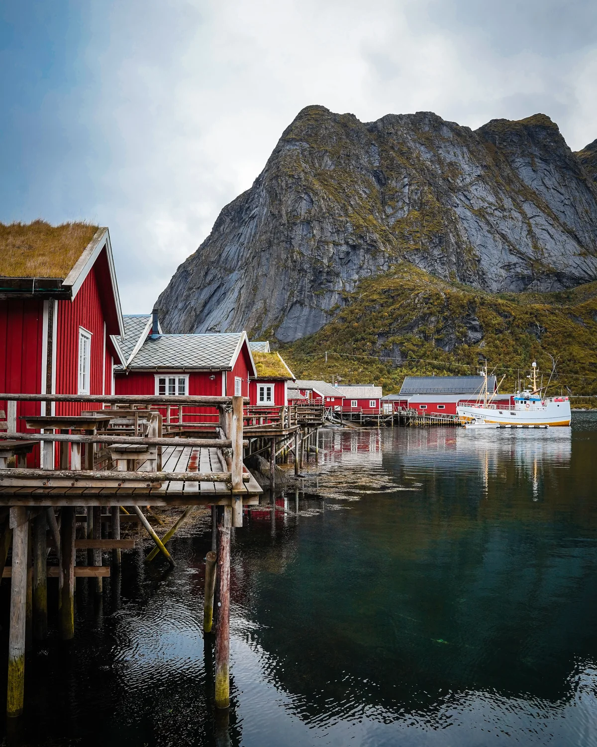 Red fishing cabins beside a Norwegian fjord